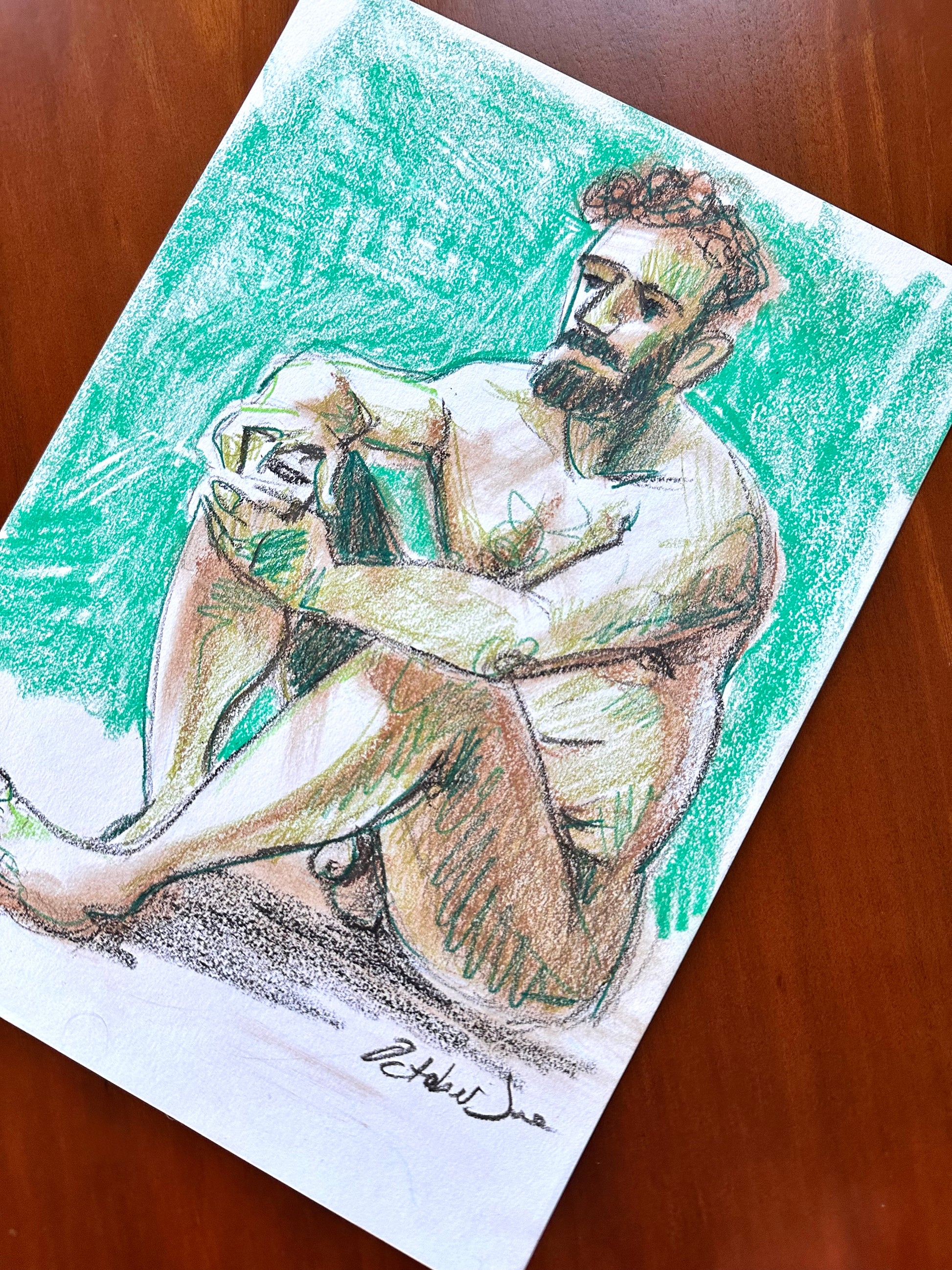 Colorful drawing of a nude figure on a wooden surface