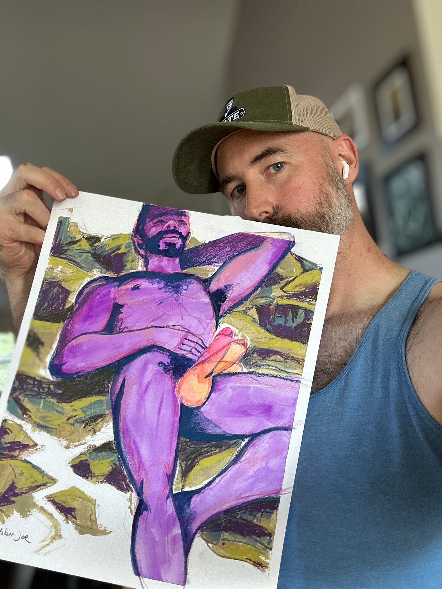 Man holding a drawing of a stylized figure with purple and yellow colors.